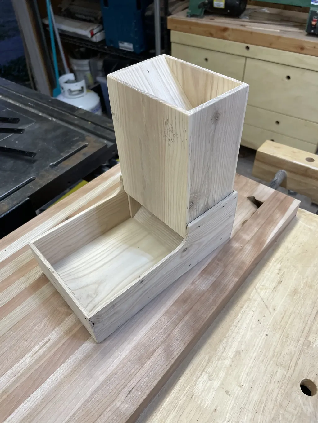 A finished wooden dice tower built in a Tinkery workshop
