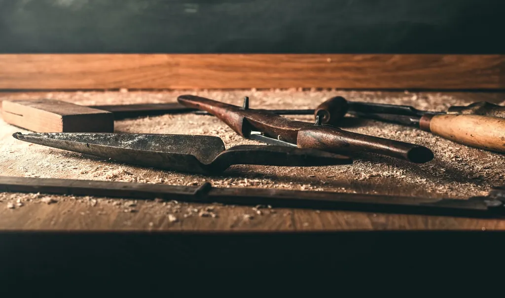 A row of well-used hand tools on a workbench