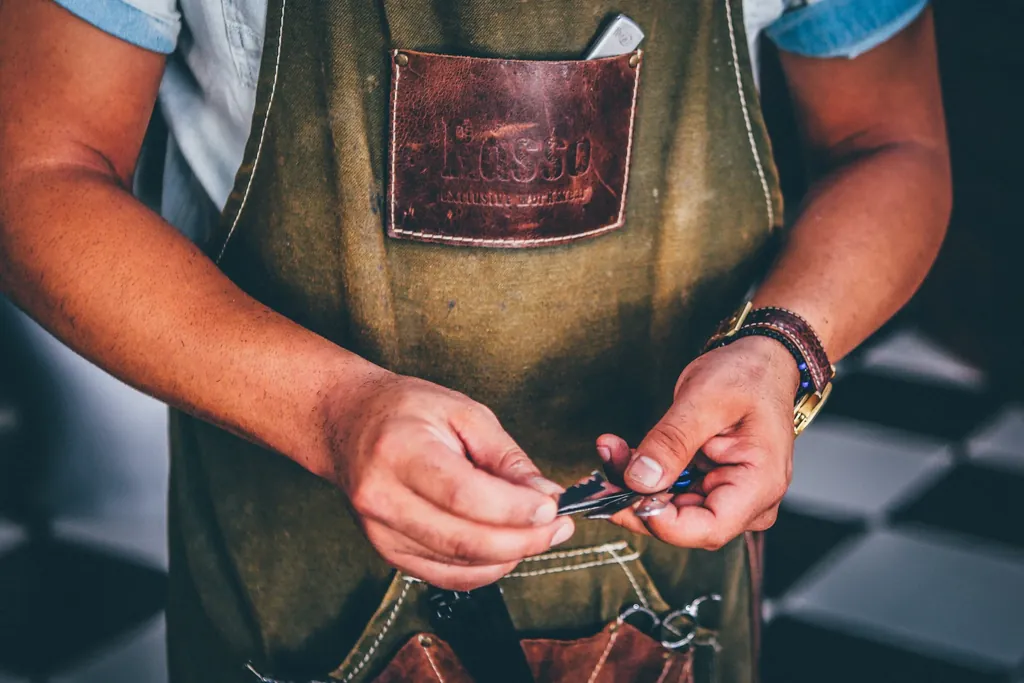 A maker in a leather apron working with hand tools