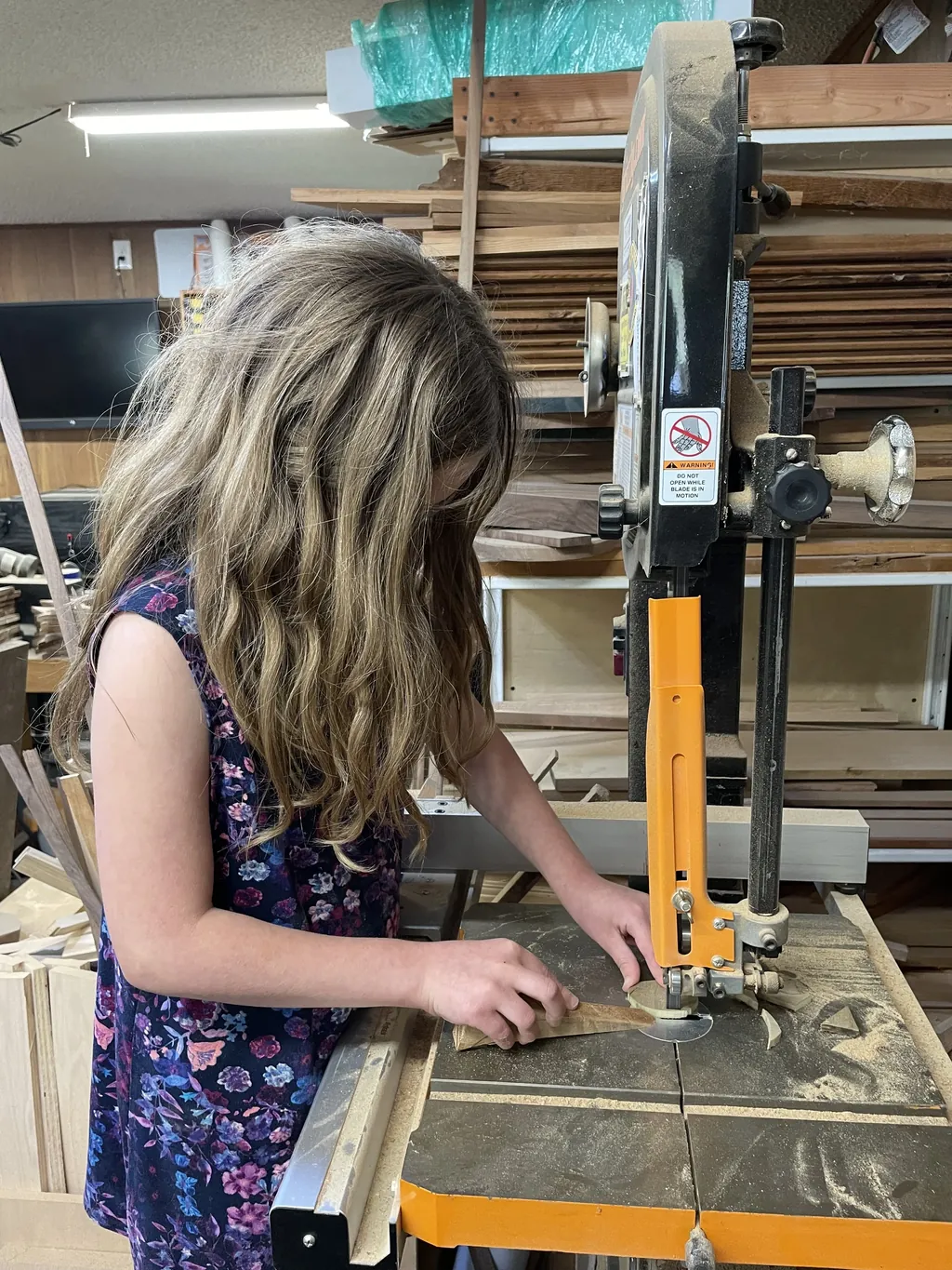 A young maker using a bandsaw during a Tinkery workshop